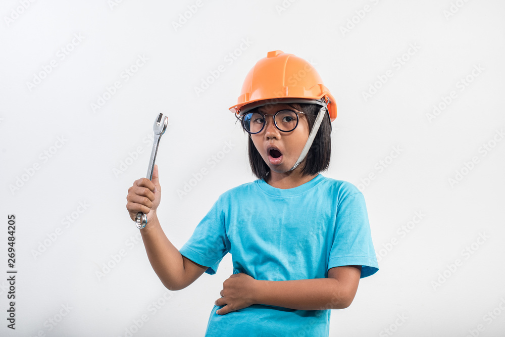 Little girl wearing orange helmet in studio shot Little girl wearing orange helmet in studio shot