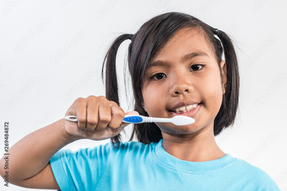 little girl brushing her teeth in studio shot little girl brushing her teeth in studio shot