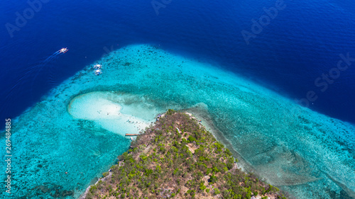 Aerial view of the Sumilon island, sandy beach with tourists swimming in beautiful clear sea water of the Sumilon island beach, Oslob, Cebu, Philippines. © Kalyakan