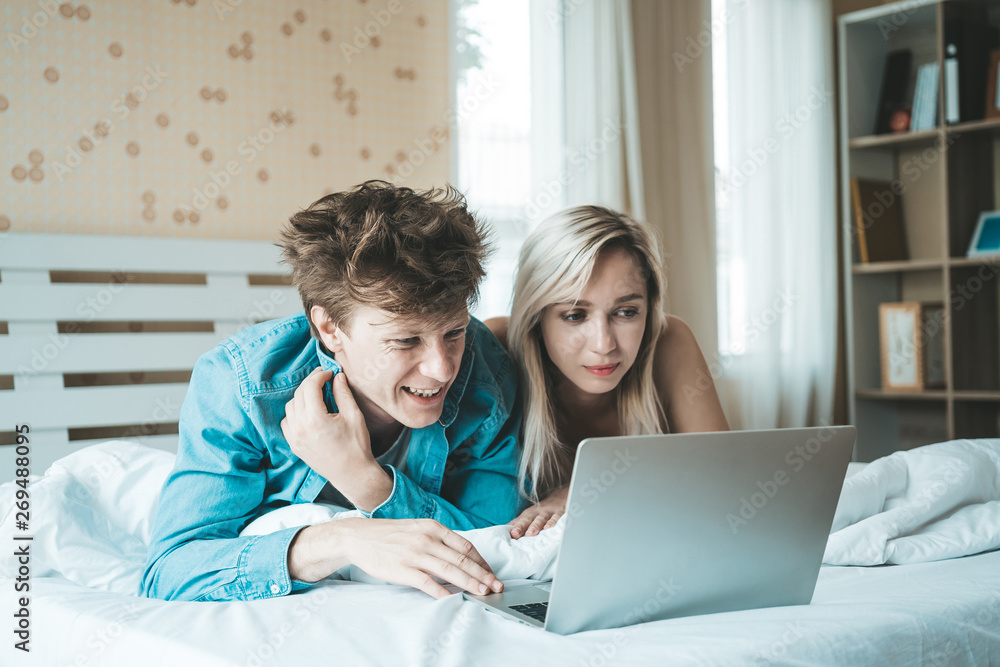 Happy couple Using laptop computer on the bed Happy couple Using laptop computer on the bed