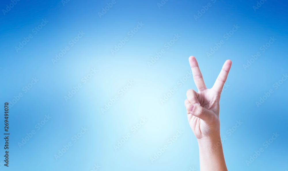 Success concept: hand doing number two gesture on blue background Success concept: hand doing number two gesture on blue background