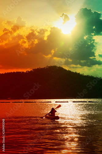 kayaking on the lake and sunset on behind the mountain background © nitimongkolchai