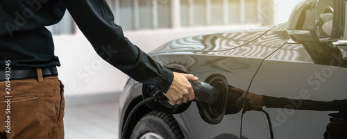 Obraz na płótnie Banner of Closeup asian Technician hand is charging the electric car or EV in service center for maintainance, Eco-friendly alternative energy concept, cover and banners w salonie