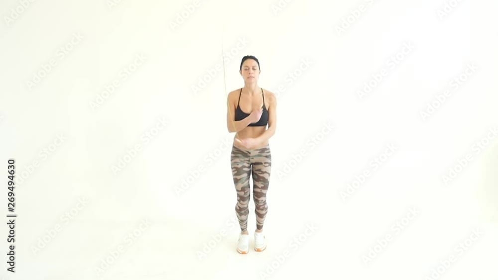 Woman Jumping with a Skipping Rope against a White Background Woman Jumping with a Skipping Rope against a White Background