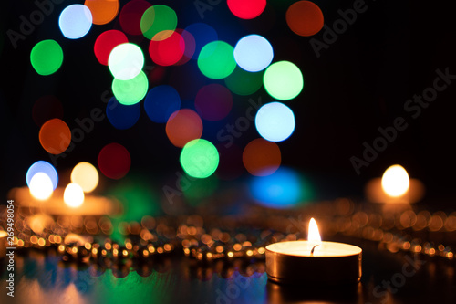 Fire of candle on christmas background. Christmas candles burning at night. Abstract candles background. Golden light of candle flame. Hope  fire. Candle lights in the darkness.