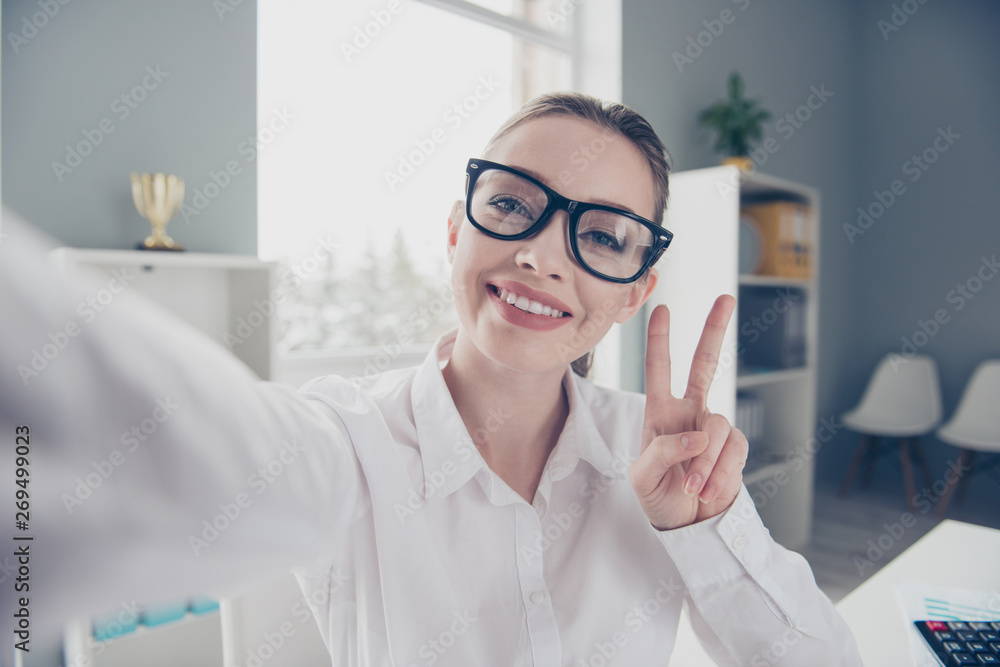 Close up photo beautiful she her business lady eyewear eyeglasses hands arms telephone v-sign friendly toothy say hi colleagues sit table wear specs formal-wear white shirt modern bright office Close up photo beautiful she her business lady eyewear eyeglasses hands arms telephone v-sign friendly toothy say hi colleagues sit table wear specs formal-wear white shirt modern bright office