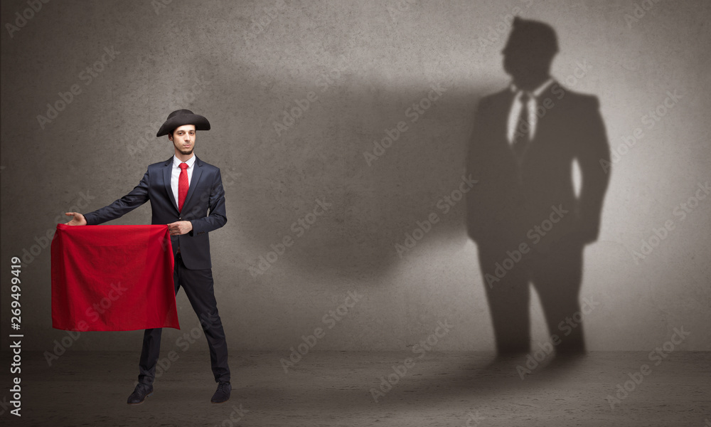 Fototapeta premium Businessman standing with red cloth on his hand and his shadow on the background 