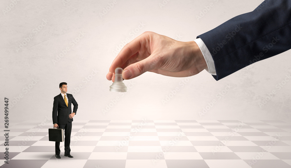 Small businessman fighting against big chessman on a big hand with chess board concept
Small businessman fighting against big chessman on a big hand with chess board concept