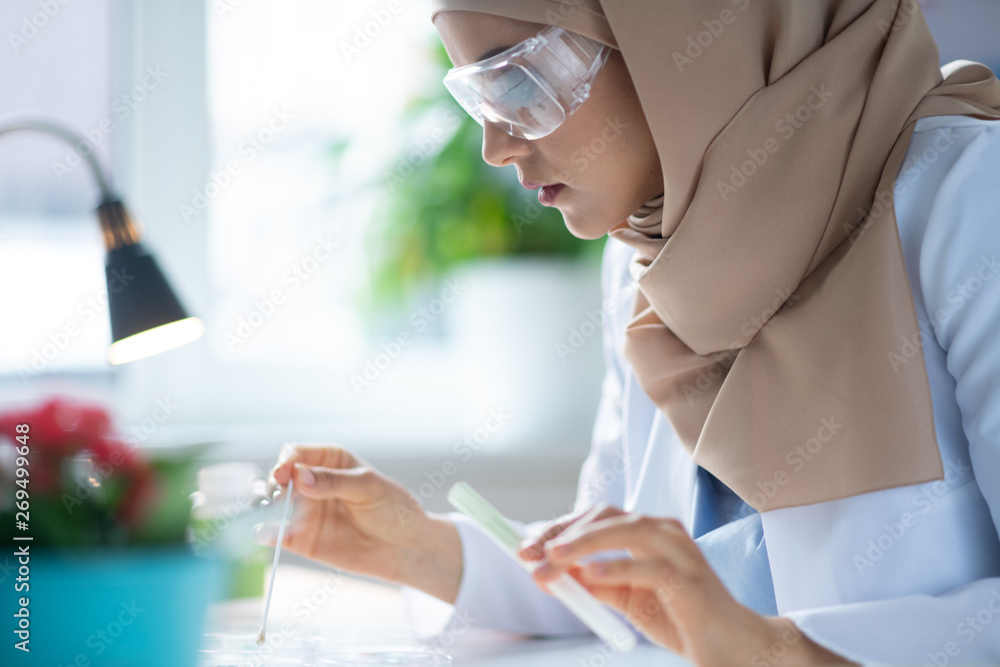 Chemist wearing protective glasses making some experiment Chemist wearing protective glasses making some experiment