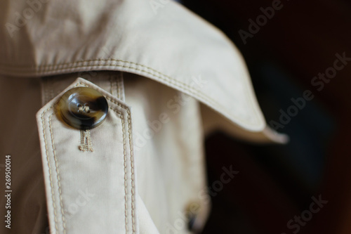 woman trench closeup details: button and collar. Gabardine fabric and button photo