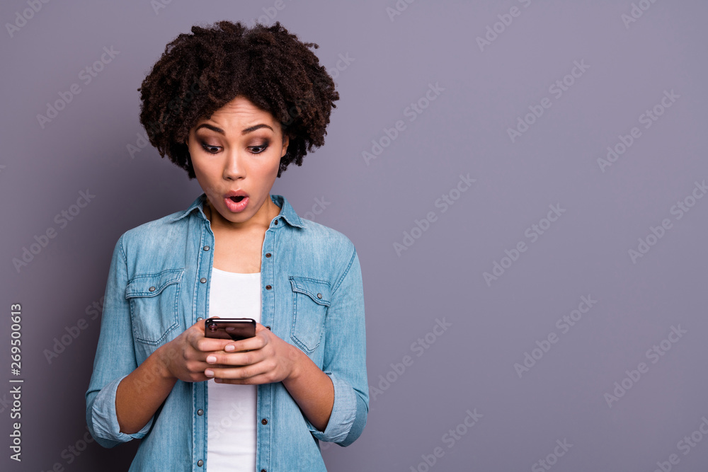 Portrait of astonished funny funky lady hold hand use user gadget look news feed impressed horrible information fear stress depressed dressed jeans outfit isolated grey background Portrait of astonished funny funky lady hold hand use user gadget look news feed impressed horrible information fear stress depressed dressed jeans outfit isolated grey background