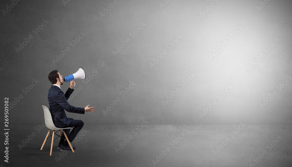 Businessman staying in an empty grey dark room with stuffs on his lap
Businessman staying in an empty grey dark room with stuffs on his lap