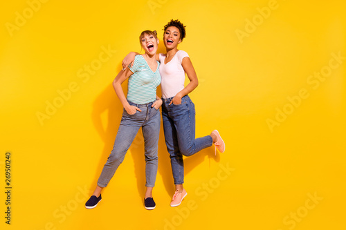 Full length body size photo beautiful she her lady laugh laughter buddies fellows different nationalities hands arms pockets wear casual white striped t-shirt clothes isolated yellow bright background