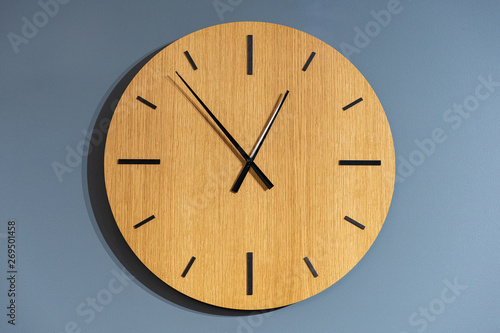 wooden clock closeup on the blue wall