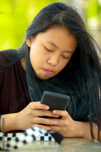 Teenage asian girl playing with smartphone