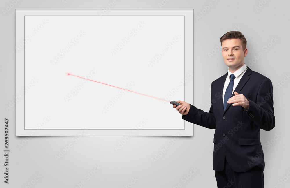 Young businessman with laser pointer and copyspace white blackboard Young businessman with laser pointer and copyspace white blackboard