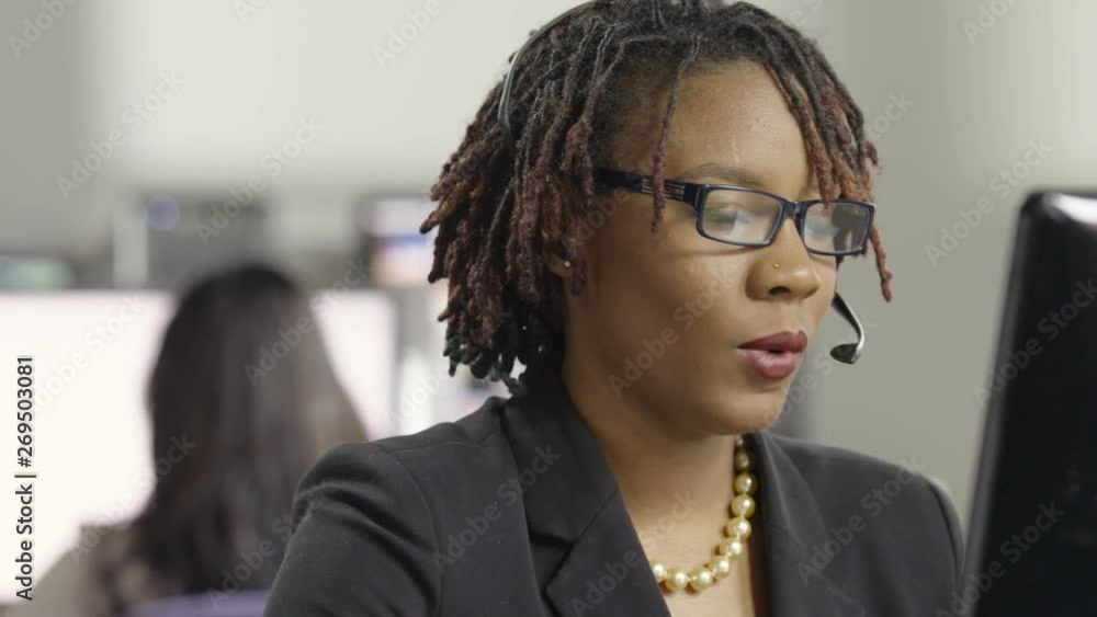Young female customer service representative talking with headphones