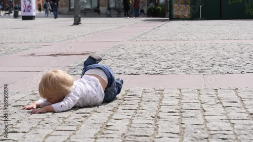 Toddler funny baby boy unexpectedly stumble and fall trying chase catch city pigeon bird that flying away frightened