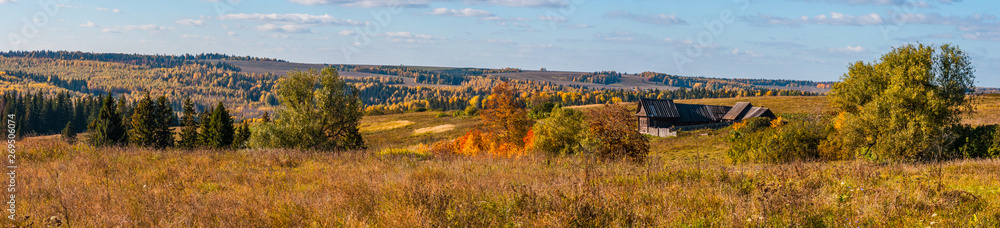 Fototapeta premium Panoramiczny widok starego wiejskiego domu i pola w słoneczny dzień, z chmurami na niebie, panorama z kilku kadrów, Stone Hill, Mari El, Rosja
