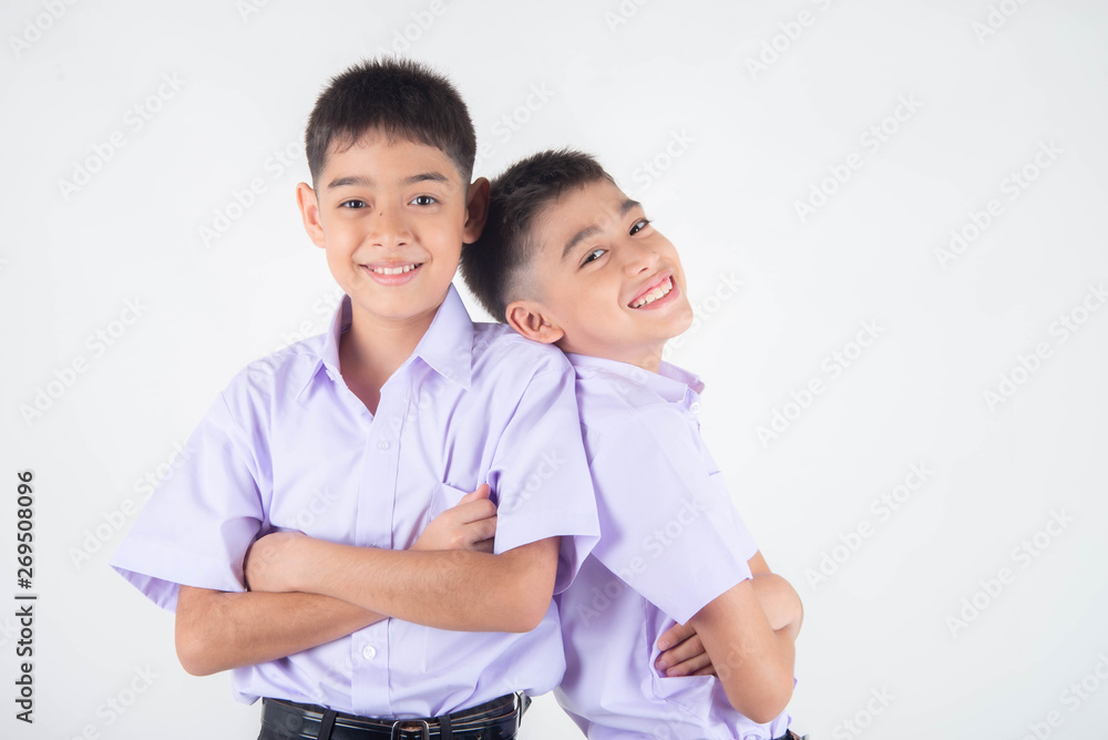 Little Asian sibling boys in student uniform pose together on white background Little Asian sibling boys in student uniform pose together on white background