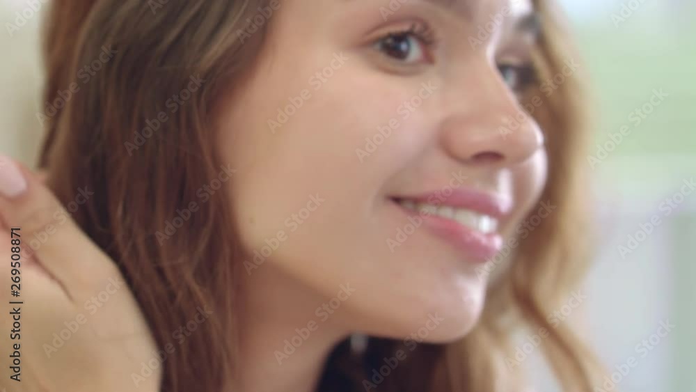 Happy woman looking at face in mirror at home bathroom. Portrait smiling woman Happy woman looking at face in mirror at home bathroom. Portrait smiling woman
