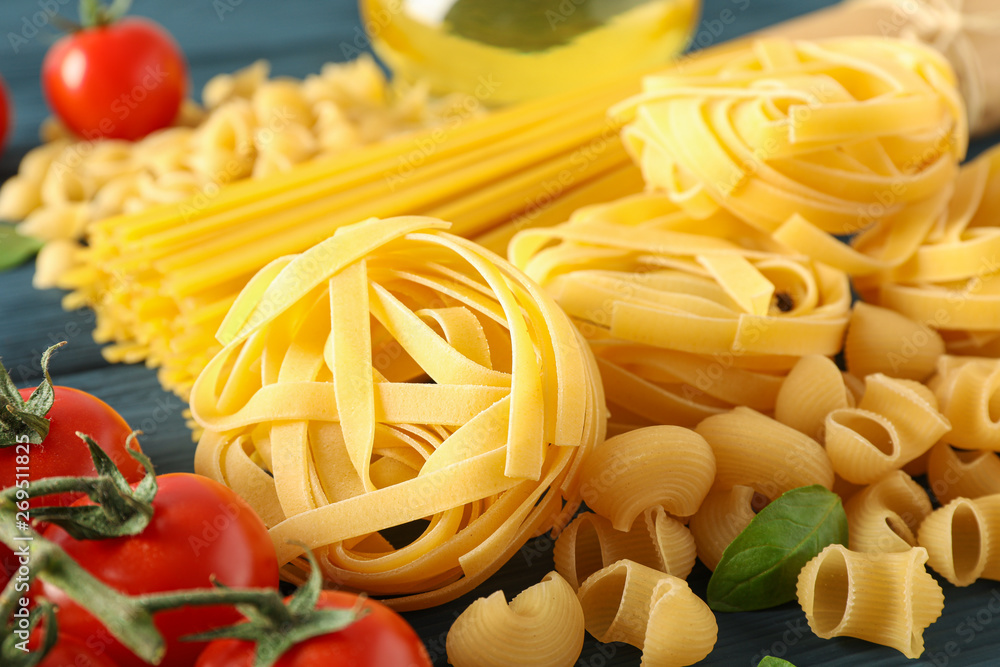Composition with pasta ingredients on wooden background, space for text and closeup