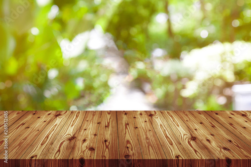Perspective wooden table on top over blur natural background, can be used mock up for montage products display or design layout.