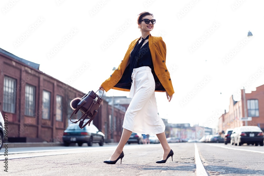 Happy young business woman walking on the street. - obrazy, fototapety, plakaty 