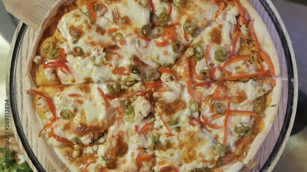 Pizza on a wooden board in a pizzeria.