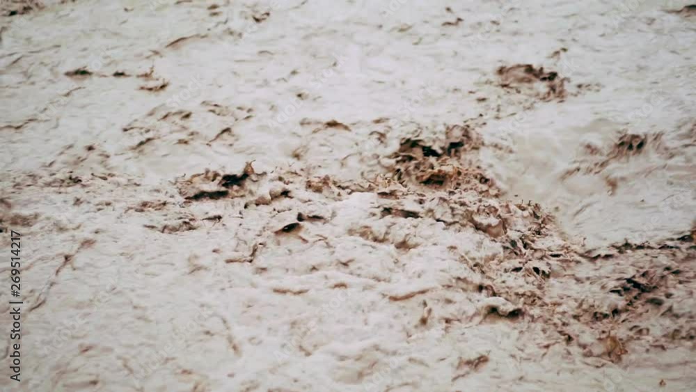 Flood after rain or hurricane. Dirty brown strong water flowing gushing into river. Close up footage Flood after rain or hurricane. Dirty brown strong water flowing gushing into river. Close up footage