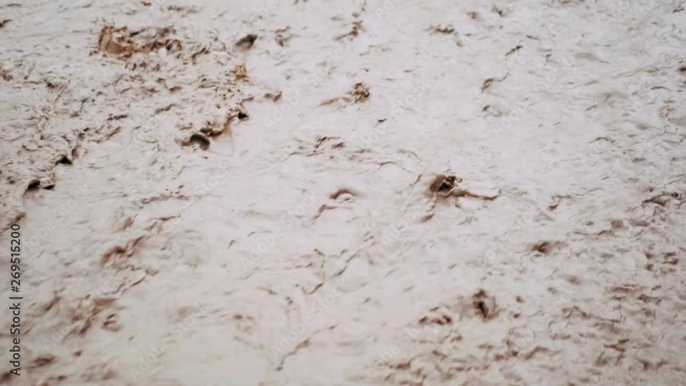 Flood after rain or hurricane. Dirty brown strong water flowing gushing into river. Close up footage Flood after rain or hurricane. Dirty brown strong water flowing gushing into river. Close up footage