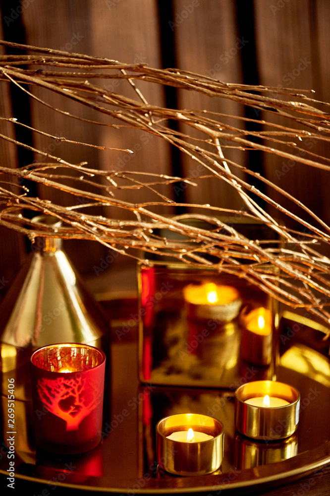 Cozy decor. Gold and red. Burning candles, Golden vessels