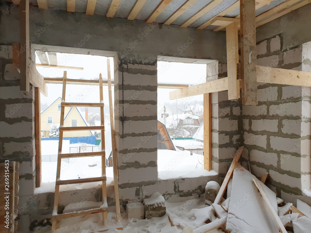 interior of a country house under construction. Site on which the walls are built of gas concrete blocks with wooden formwork interior of a country house under construction. Site on which the walls are built of gas concrete blocks with wooden formwork