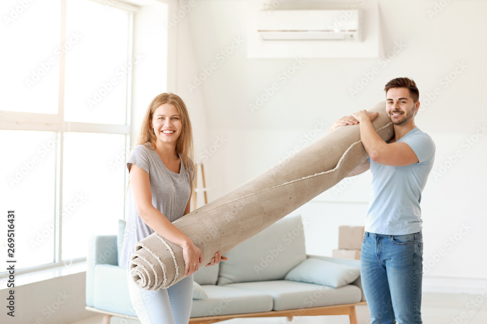 Young couple with carpet in new flat Young couple with carpet in new flat