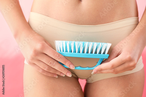 Beautiful young woman with cleaning brush, closeup. Depilation concept