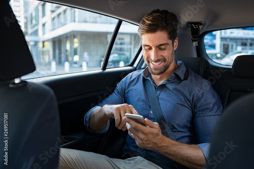 Foto Happy business man in car using phone