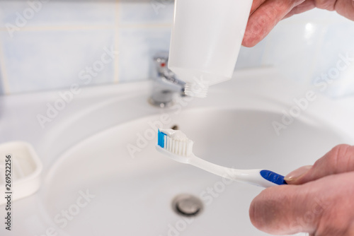 Person putting toothpaste on toothbrush © Voyagerix