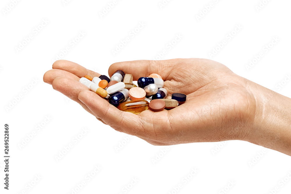 Man's hand holding a heap of different pills isolated on white background. Close up. High resolution product. Healthcare concept Man's hand holding a heap of different pills isolated on white background. Close up. High resolution product. Healthcare concept