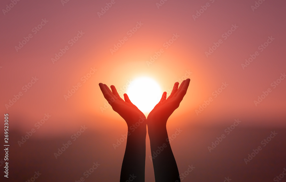 Free concept: Raised hands catching sun on sunset sky - obrazy, fototapety, plakaty 
