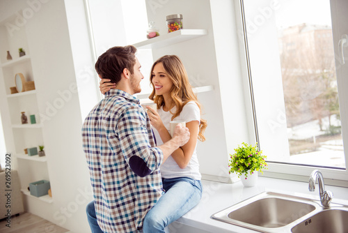 Close up photo pair beautiful he him his macho she her lady just married overjoyed hot beverage hands bonding tell speak communicate say secrets hugging apartments flat bright kitchen room indoors © deagreez