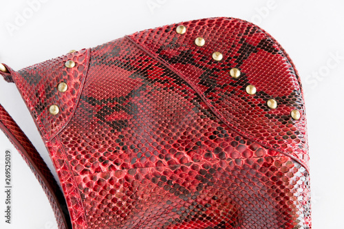Red leather handbag made of Python skin on a white background. Fashion women's accessories. The view from the top. Python skin. Red clutch. Leather bag.