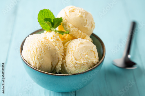 Vanilla ice cream balls with mint in a turquoise bowl
