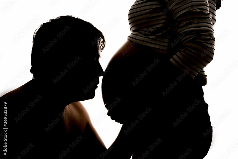 Back light of a pregnant woman. Silhouette of young pregnant female and dad male on white background. Backlit silhouette. Father and mother enjoying.