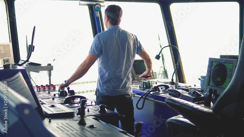 Marine navigational officer during navigational watch on Bridge . Work at sea photo