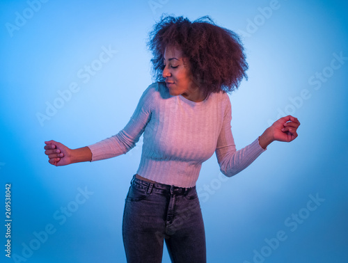 Attractive yong african american woman dancing and having fun in moody disco light