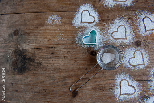 Heart powdered sugar on the rustic background