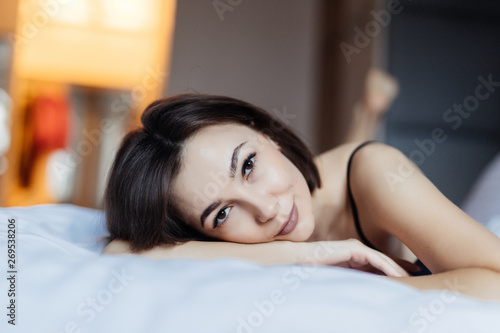 Young pretty woman lying in bed at home