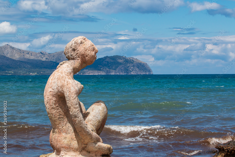stones on the beachsculpture of a woman made of stone by the sea and blue sky stones on the beachsculpture of a woman made of stone by the sea and blue sky