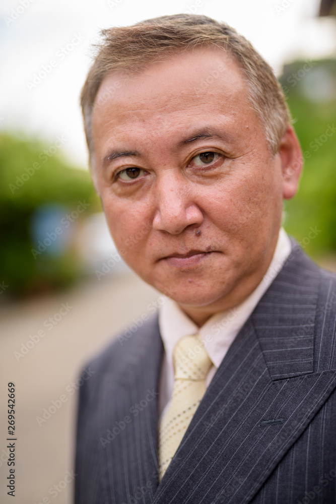 Mature Asian businessman in the streets outdoors Mature Asian businessman in the streets outdoors