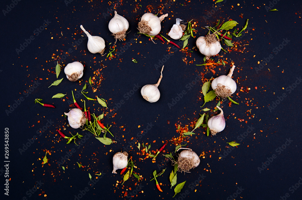 Chilli peppers, garlic, cherry tomatoes and spices on the black background. Chilli peppers, garlic, cherry tomatoes and spices on the black background.